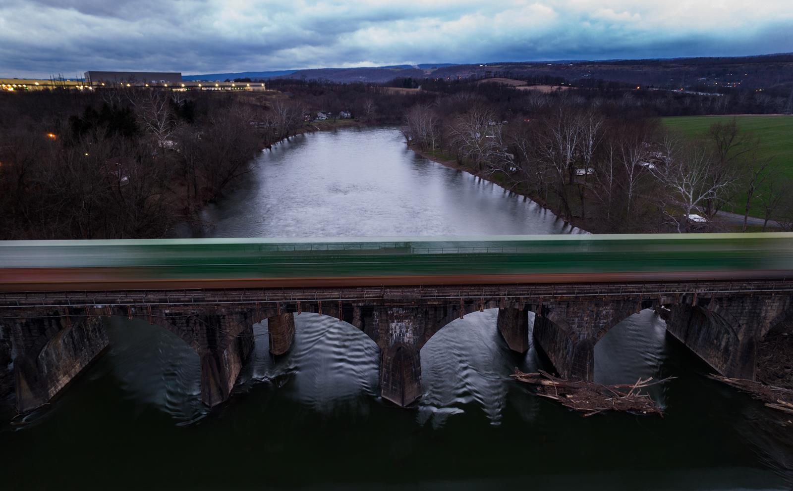 A  Norfolk Southern coal train spans the stone arch bridge crossing the Juniata River near Lewistown, PA