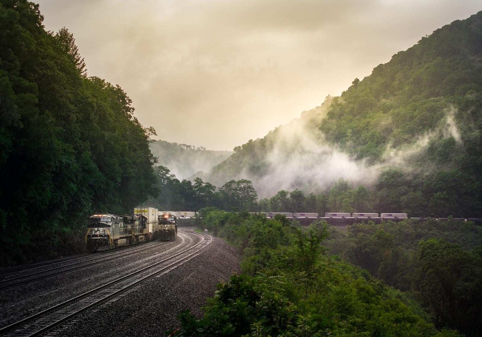 A Norfolk Southern intermodal train overtakes an empty oil train as they both head westward at the Horseshoe Curve.